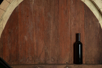 Bottle of red wine on a wooden background in a winery