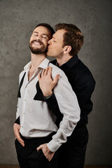 A photo of a loving gay couple in stylish suits, embracing each other.