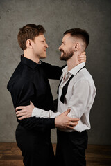 Two men in elegant suits embrace and share a loving gaze.