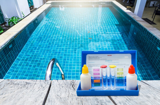 Swimming pool water tester test kit over on swimming pool edge, water quality check, pool maintenance calendar, water test kit, pool check list and report