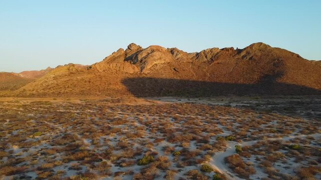 Desert landscape during golden hour with hills in the background, baja california sur