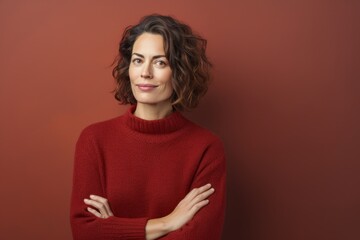 Obraz premium Portrait of a content woman in her 40s dressed in a warm wool sweater isolated on blank studio backdrop