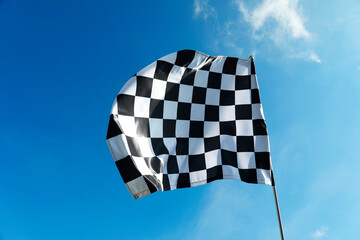 One checkered flag against blue sky outdoors