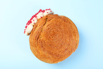 One supreme croissant with cream on light blue background, top view. Tasty puff pastry