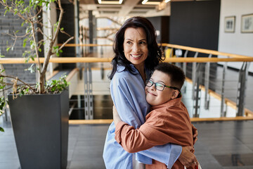Fototapeta premium A mother and son with Down syndrome share a loving embrace in a shopping mall.