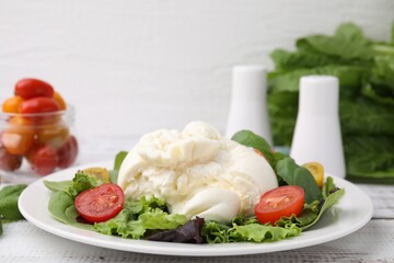 Delicious fresh burrata salad on white wooden table