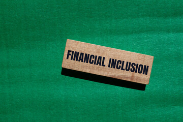 Financial inclusion message written on wooden block with green background. Conceptual financial inclusion symbol. Copy space.