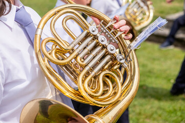 three musicians in a row playing the horn in a marching band at an outdoor parade