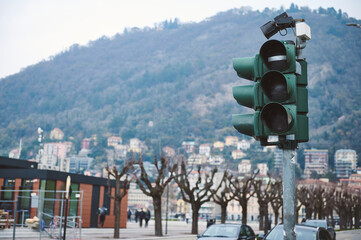 Traffic lights in an urban setting with mountain backdrop on a cloudy day