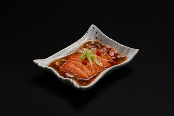 Salmon marinated soy sauce in Korean style with chili and garlic isolate on black background