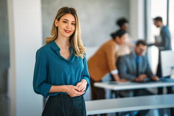 Portrait of beautiful business woman in front of business team. Office success people concept