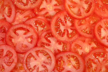 Red background, slices of ripe tomatoes in flat lay