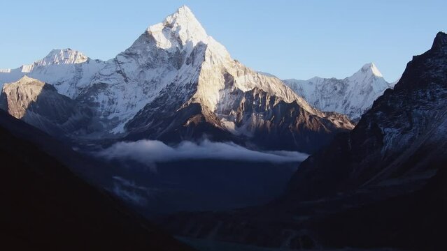 Close up zoom out Ama dablam mountain peak and Chola lake. View from Dzongla village.Everest base camp trek detour route and visible peaks concept.Sagarmatha national park