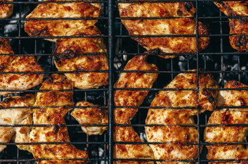 Fresh chicken meat is gradually fried on grill, emitting unique smell that arouses appetite.