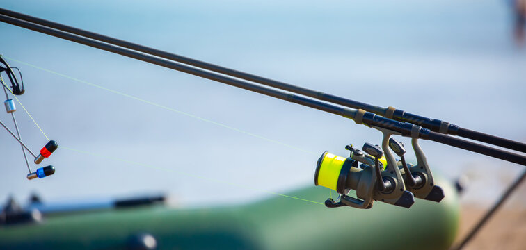 Close-up of fishing rod reels. Fishing on the shore of the lake. Spinning rods for sport fishing.