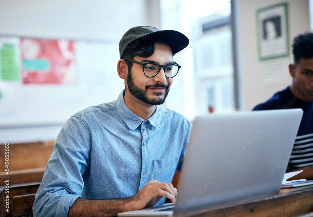 Poster Man, classroom and university with laptop for research, reading message on application at school. Male student, college or social media with education or learning, scroll for news story with glasses