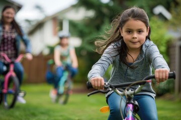 Obraz premium A child girl with a concentration on her face as she practices riding a bicycle without training wheels in her backyard. Children's Day.