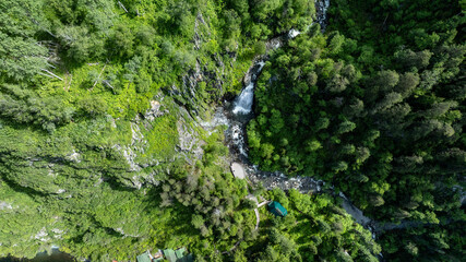 summer panoramic landscape of mountains and forest and waterfall against the sky in the area of ​​Lake Teletskoye in Altai