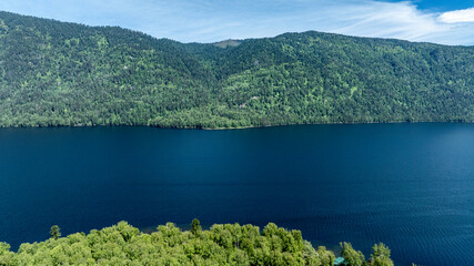 summer panoramic landscape of mountains and forest and waterfall against the sky in the area of ​​Lake Teletskoye in Altai