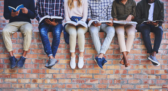 University student, friends and books on wall with legs, learning and progress for development at campus. People, group and scholarship for education, information and knowledge for future at college