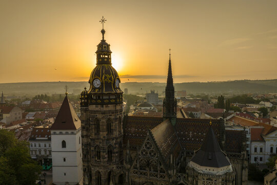 Skyline of the city of Kosice, Cathedral tower and birds flying in the sky during sunrise