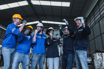 Team of successful group of male and female, corporate workers stand smiling together in industry factory