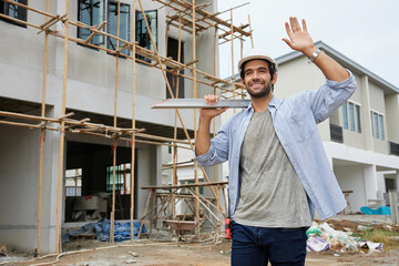 worker or architect holding a steel plank and say hello to someone at construction site