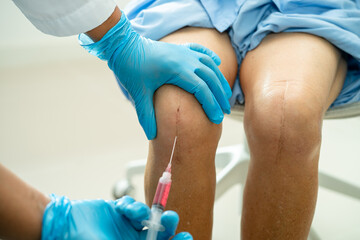 Asian doctor inject Hyaluronic acid platelet rich plasma into the knee of senior woman to walk...