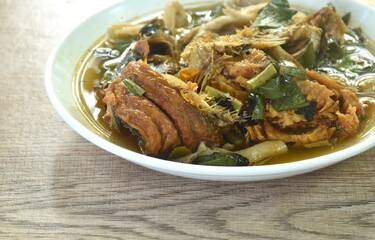 boiled smoked dry snake head fish in spicy and sour soup on plate