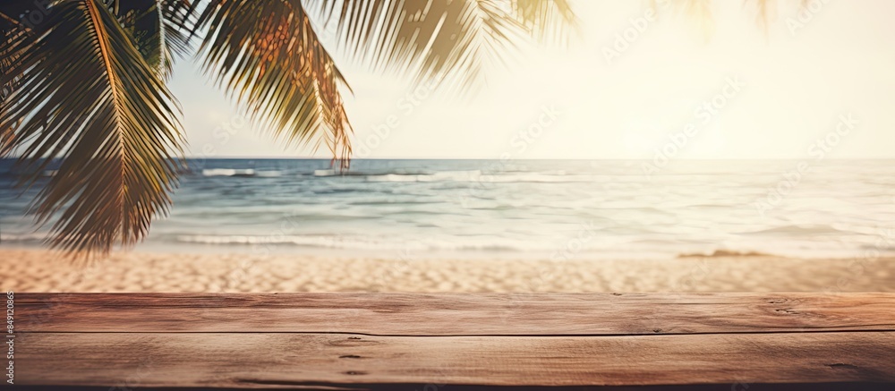 Poster Blur tropical beach with bokeh sun light wave and palm tree on copy space empty old wood table abstract background Product presentation in nature Vintage tone filter effect color style