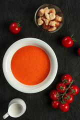 tomato cream soup in white bowl on black desk