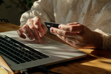 Fototapeta premium Woman making online payments using bank card sitting at desk.