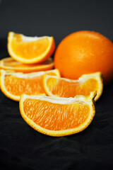 Whole and sliced ​​oranges on a dark background
