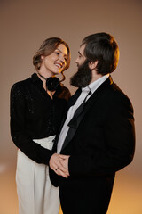 A loving couple in formal attire poses together, gazing into each others eyes.