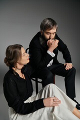 A loving couple in elegant attire pose together, creating a moment of quiet intimacy.