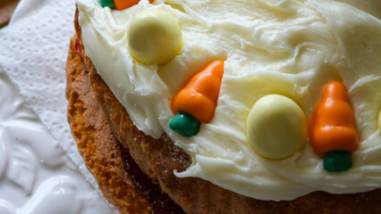 Delicious Easter Cake with white easter eggs, carrots and yummy white frosting on Victoria sponge