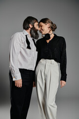 A couple in stylish attire poses for a portrait.