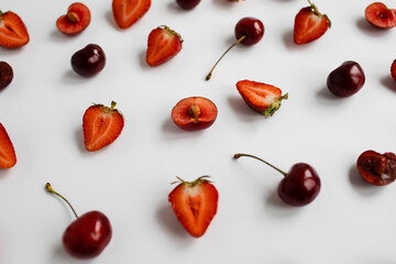Close-up cut cherry and on the background of ripe strawberries and cherries on a white background
