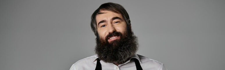 A man with a long beard smiles warmly for the camera.