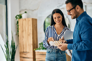 A female choosing a color of the ceramic tiles, has a salesman help, at the home design shop.