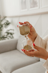 Hourglass in hand on a light background