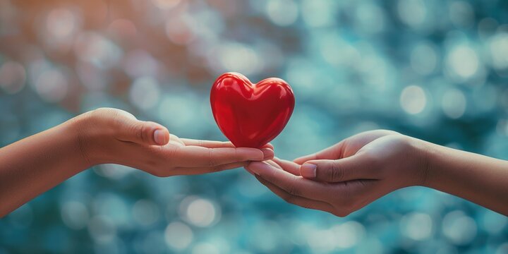 A touching image of two hands, one passing a red heart to another, symbolizing love and caring
