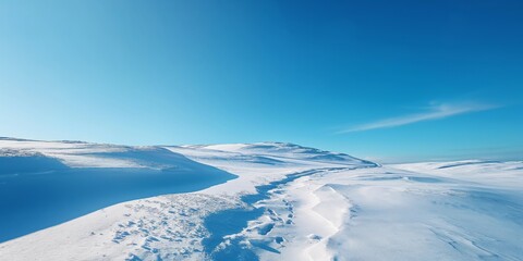 Expansive snowy hills stretch towards the horizon under a vivid blue sky, embodying a pristine winter day