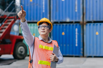 Success male worker standing hand point high for order operate control work in cargo shipping...