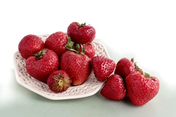 delicious berries strawberries and red flowers of strawberry plant close up