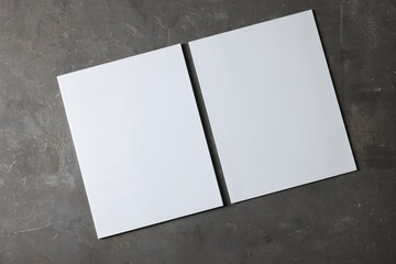 Blank paper sheets on grey textured background, top view. Mockup for design