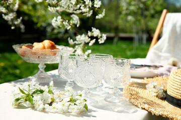 Beautiful table setting with spring flowers in garden on sunny day