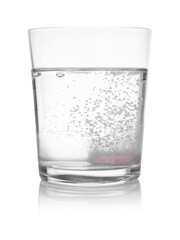 Effervescent pill dissolving in glass of water isolated on white