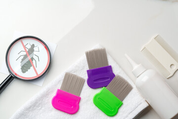 Comb, anti lice medicine and towel on white background