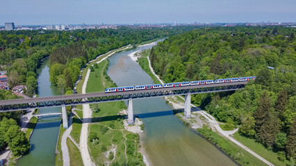 Train passing over bridge on the Isar river in Munich aerial drone video	